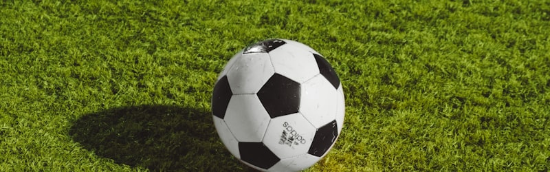 足球运动员在训练中射门，足球飞向球网